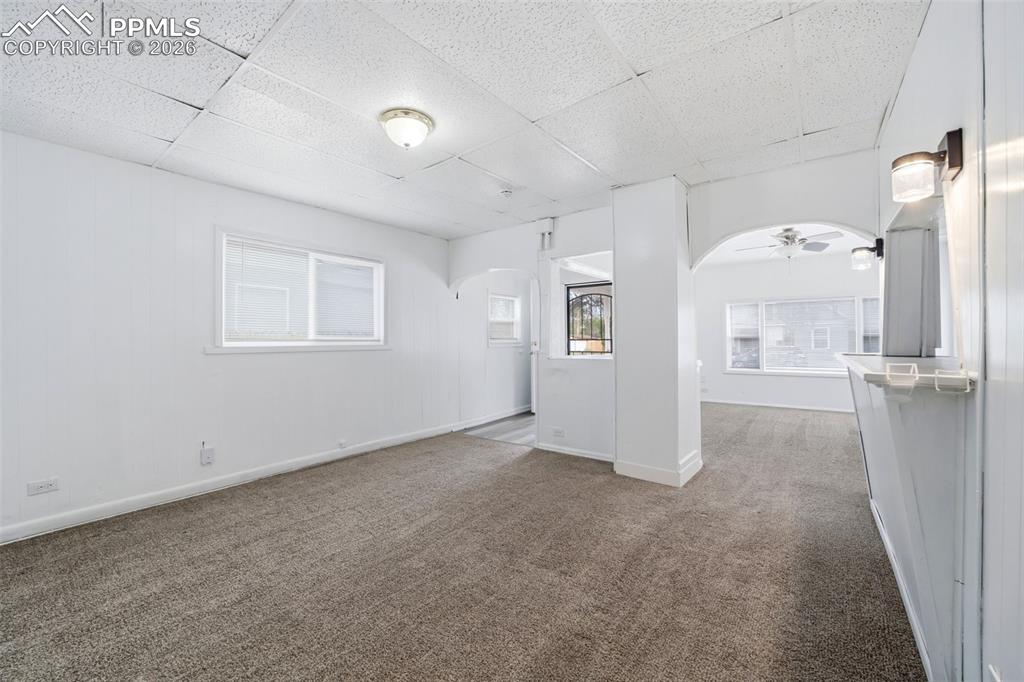Image 31 of 50: Carpeted living space with white walls and a white acoustic tile ceiling