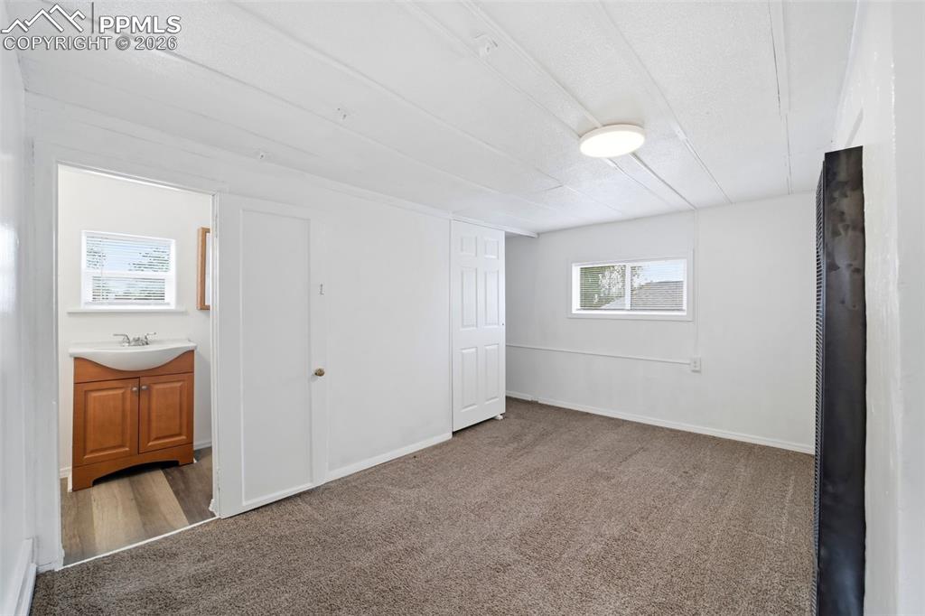 Image 37 of 50: Carpeted room featuring a ceiling-mounted light fixture and a window