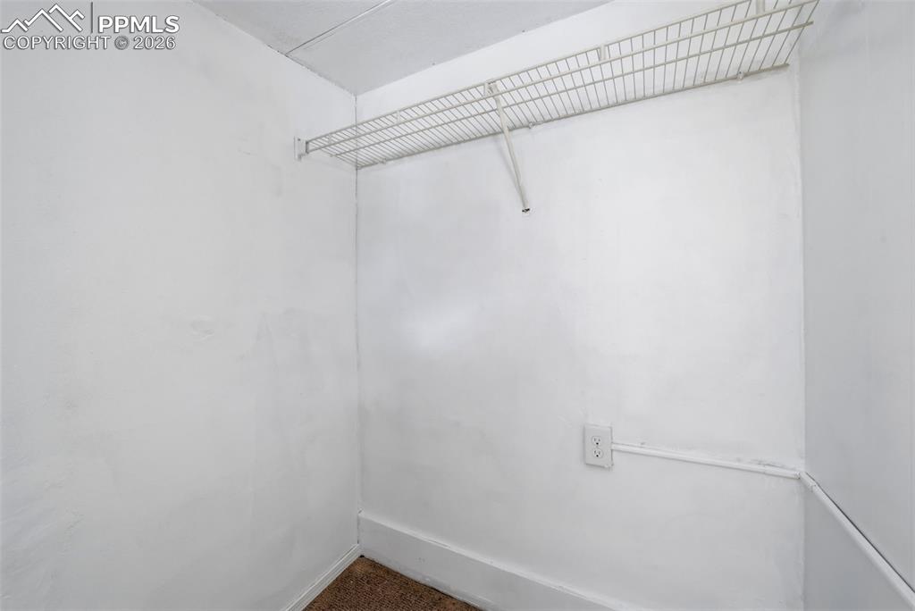 Image 39 of 50: White-painted interior space featuring a wire shelving unit, electrical out