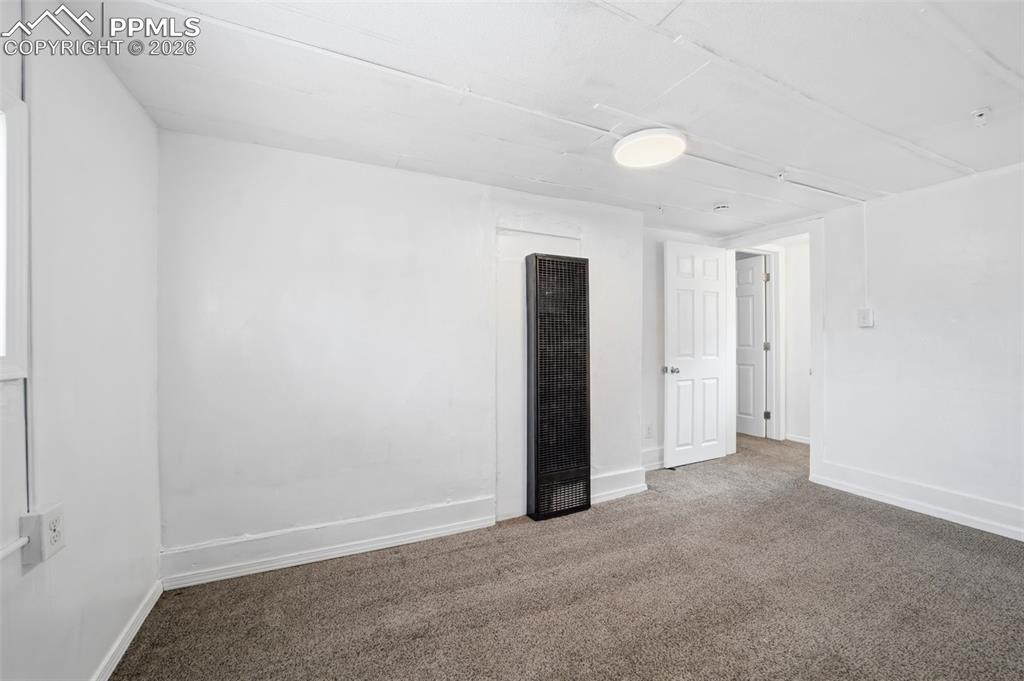 Image 40 of 50: Carpeted interior space featuring white painted walls and ceiling