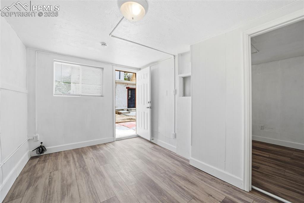 Image 5 of 50: Versatile interior space featuring wood-finish flooring, white painted wall