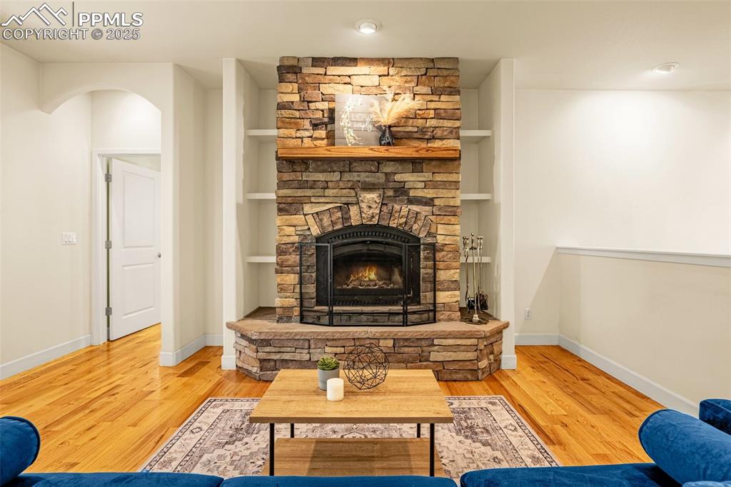 Image 3 of 41: Living area featuring a fireplace, wood finished floors, and baseboards