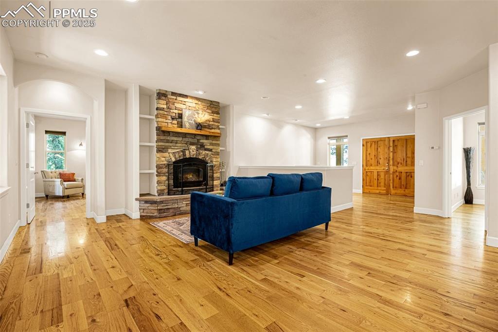 Image 4 of 41: Living area featuring light wood-style flooring, a fireplace, recessed ligh