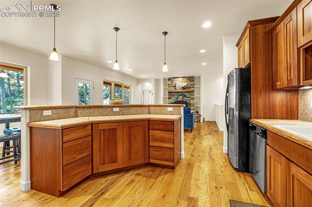 Image 5 of 41: Kitchen featuring appliances with stainless steel finishes, brown cabinetry