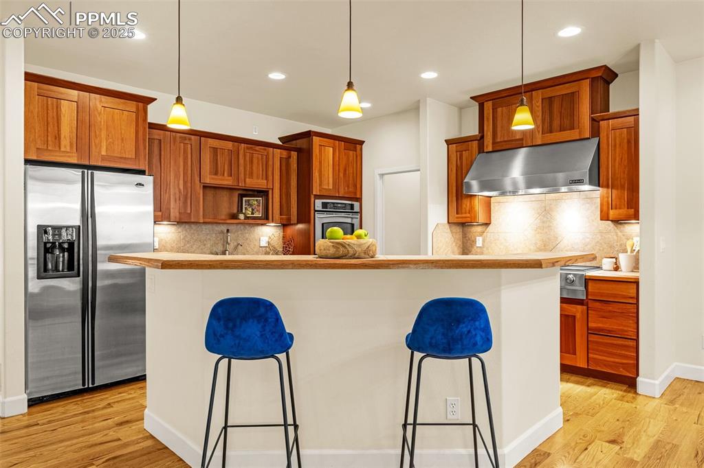 Image 8 of 41: Kitchen featuring stainless steel appliances, under cabinet range hood, a k