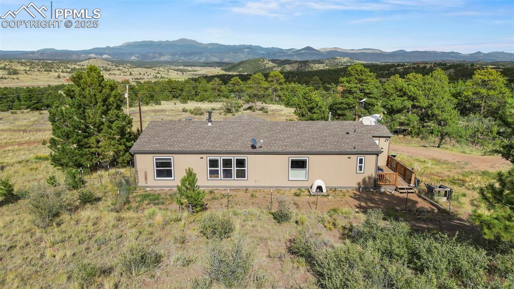 Image 31 of 41: Back of property with a deck with mountain view and roof with shingles