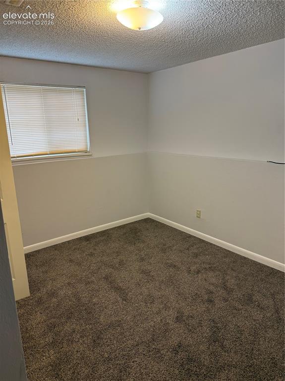 Image 11 of 16: Room featuring textured ceiling, flush mount lighting, and window with blin