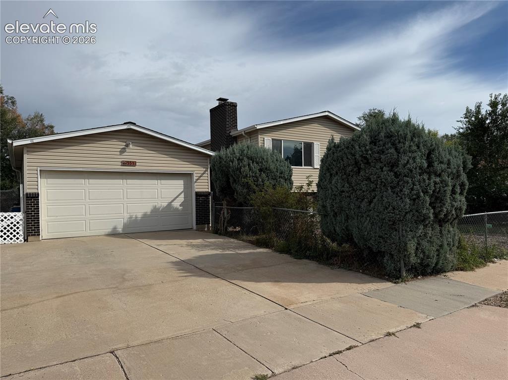 Image 2 of 16: Welcoming two-story home featuring a two-car garage with paneled doors, neu