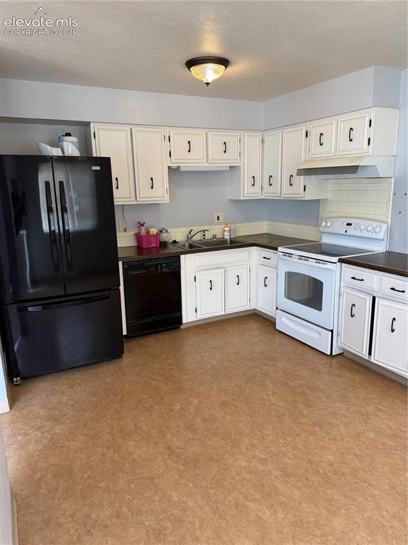 Image 4 of 16: Kitchen featuring white cabinetry with dark hardware, dark countertops, and