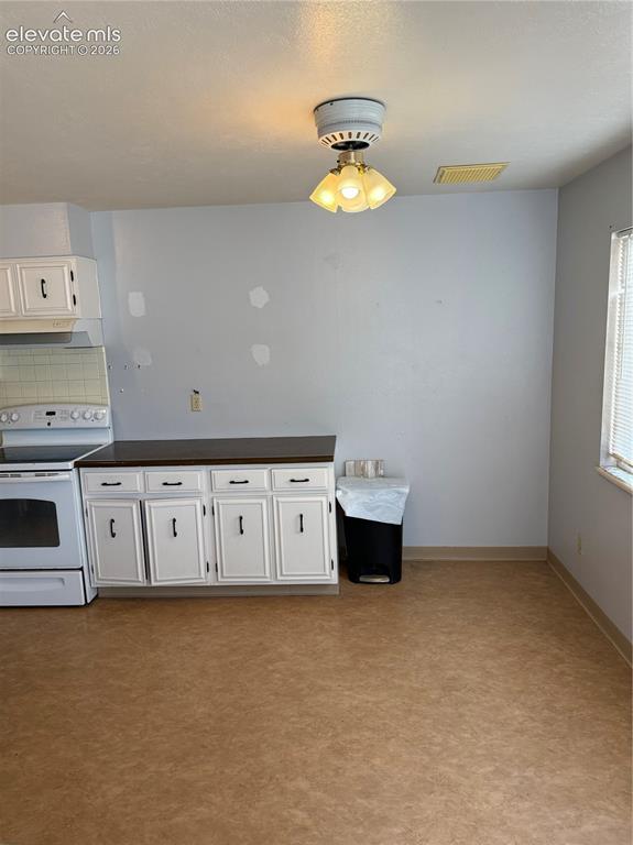 Image 5 of 16: Spacious kitchen featuring white cabinetry with hardware accents, laminate 