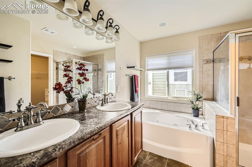 Image 20 of 34: Bathroom with a stall shower, a jetted tub, a walk in closet, double vanity