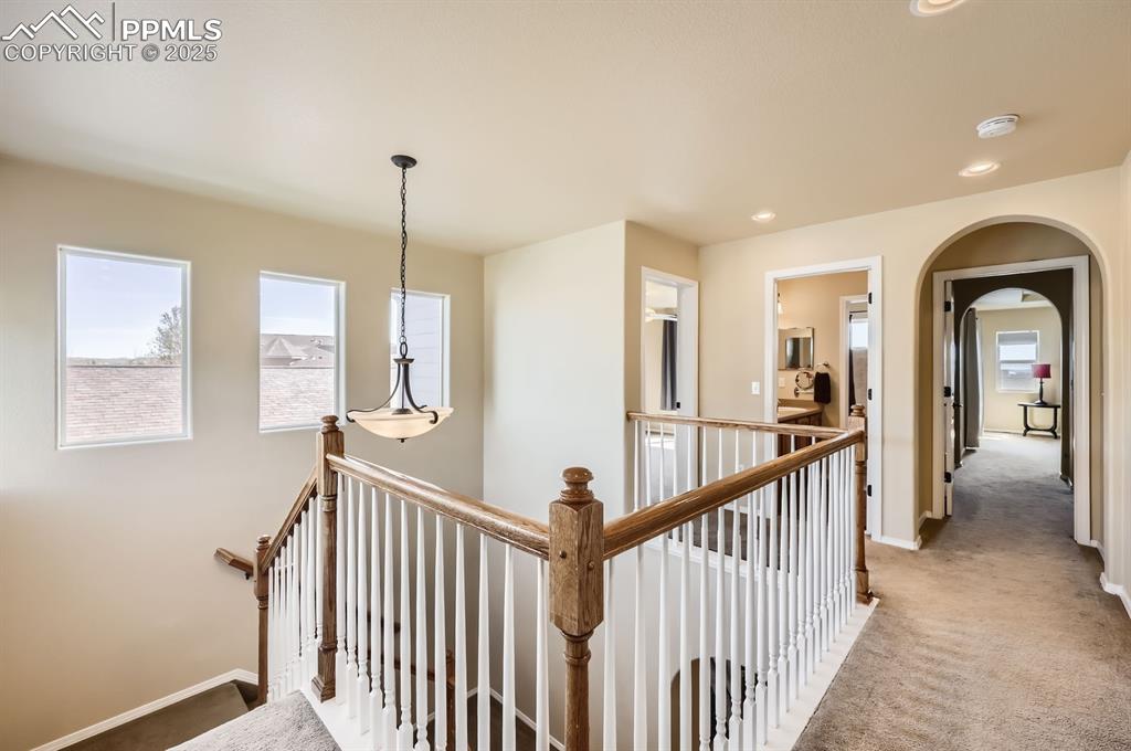 Image 25 of 34: Hall with an upstairs landing, carpet, baseboards, recessed lighting, and a