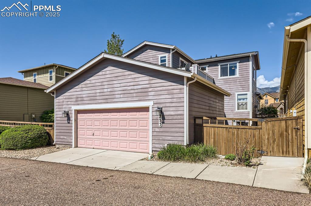 Image 29 of 34: View of front of home with fence and driveway