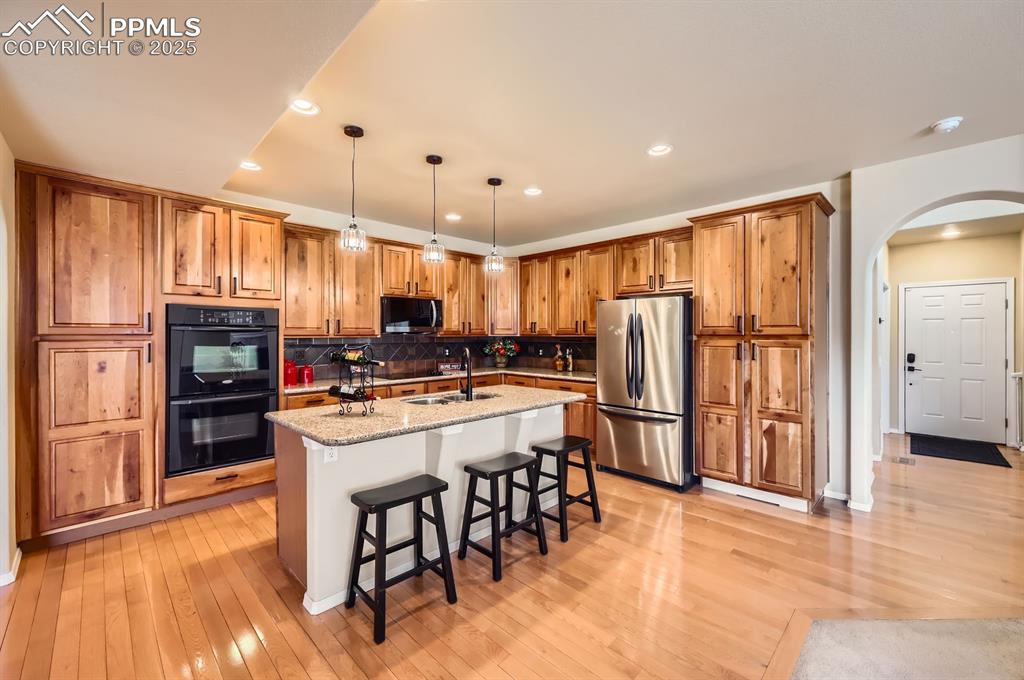 Image 7 of 34: Kitchen featuring appliances with stainless steel finishes, arched walkways