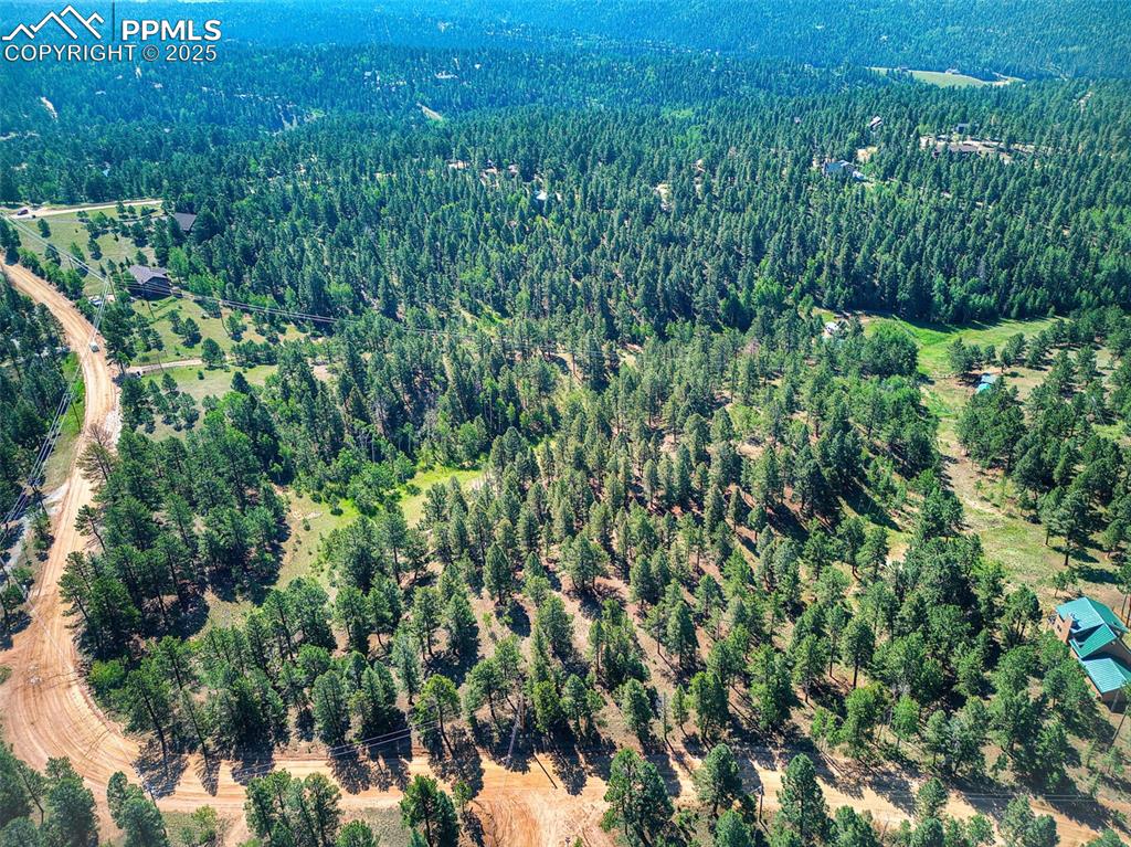 Image 21 of 26: Aerial view of property and surrounding area with a heavily wooded area