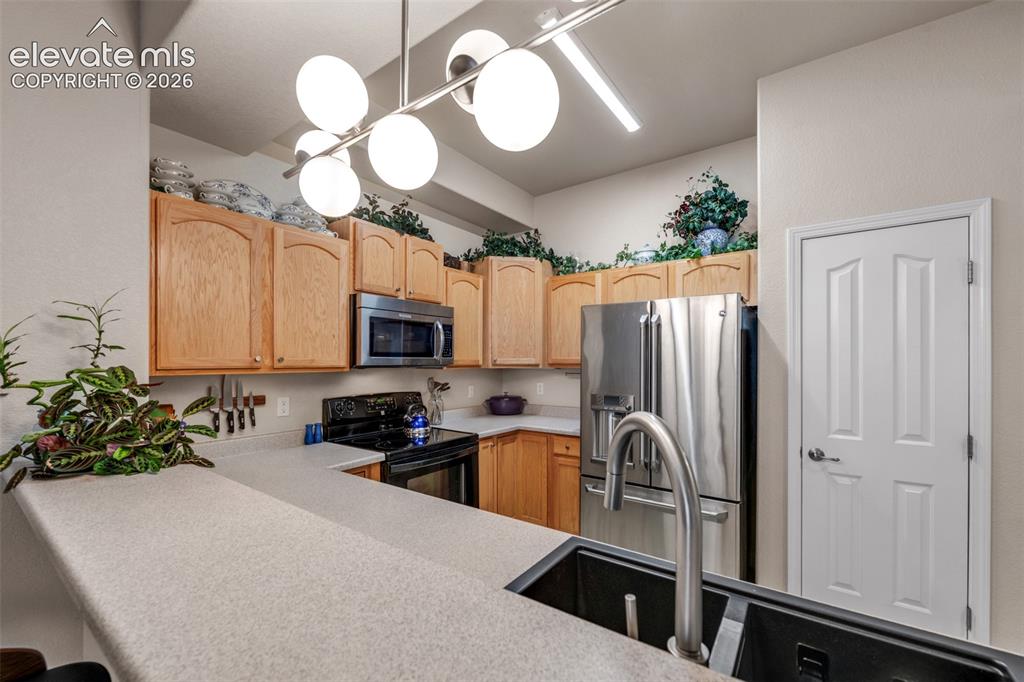 Image 11 of 32: Kitchen featuring light wood cabinetry, white countertops, built-in stainle