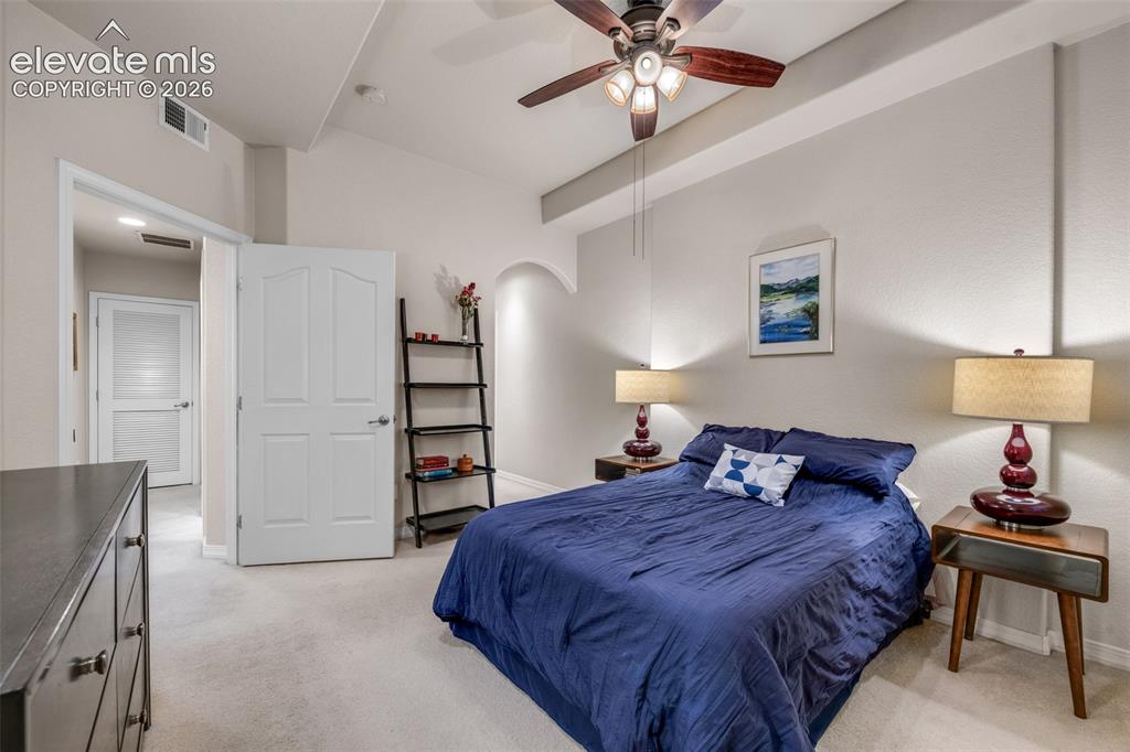 Image 16 of 32: Vaulted ceiling with an integrated ceiling fan, arched wall recess, and lig