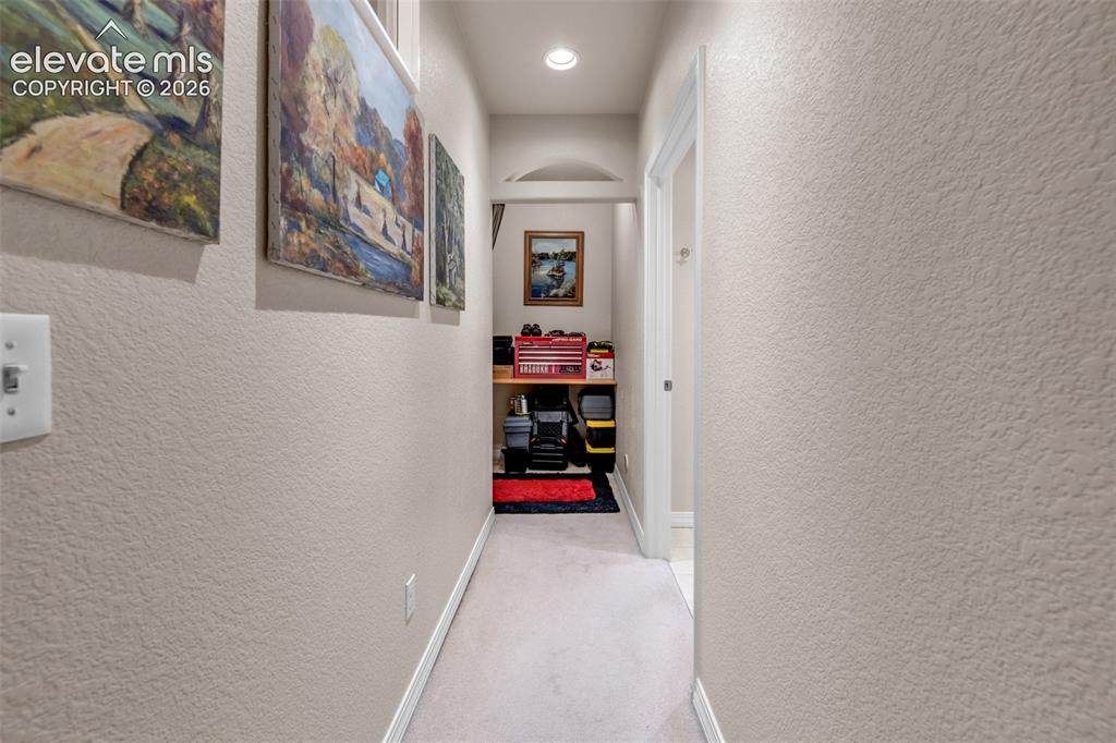 Image 17 of 32: Arched doorway leading to a recessed area with built-in shelving, complemen