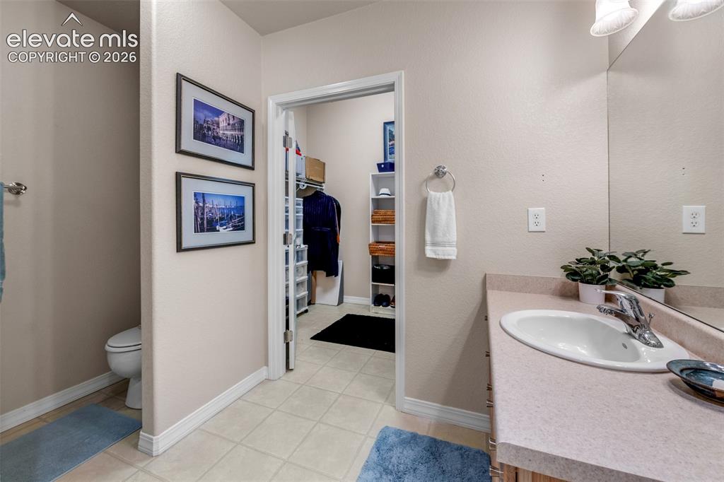 Image 19 of 32: Built-in vanity with integrated sink, chrome faucet, and expansive wall-mou