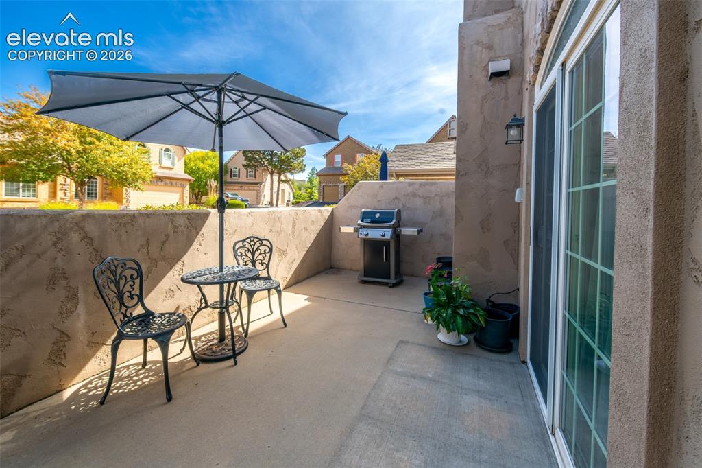 Image 23 of 32: Private patio space featuring stucco walls, concrete flooring, and a slidin