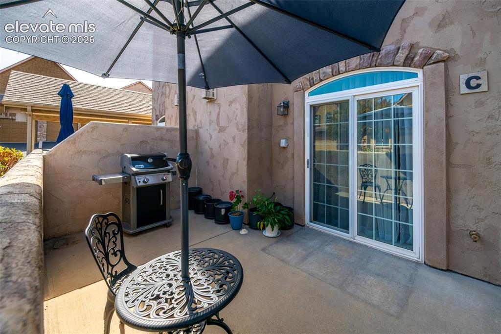 Image 24 of 32: Private patio space with a sliding glass door entry, arched transom window,