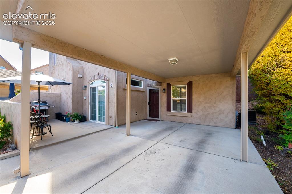 Image 26 of 32: Covered carport with concrete flooring