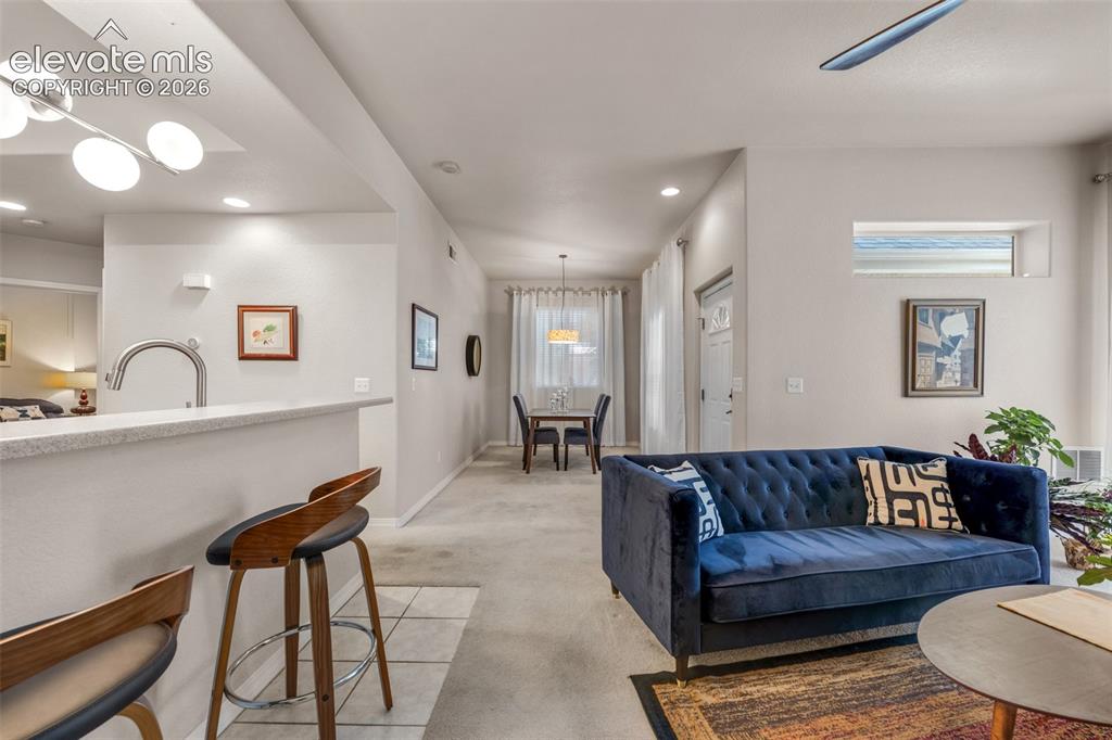Image 4 of 32: Open-concept living space featuring a breakfast bar, recessed lighting, and