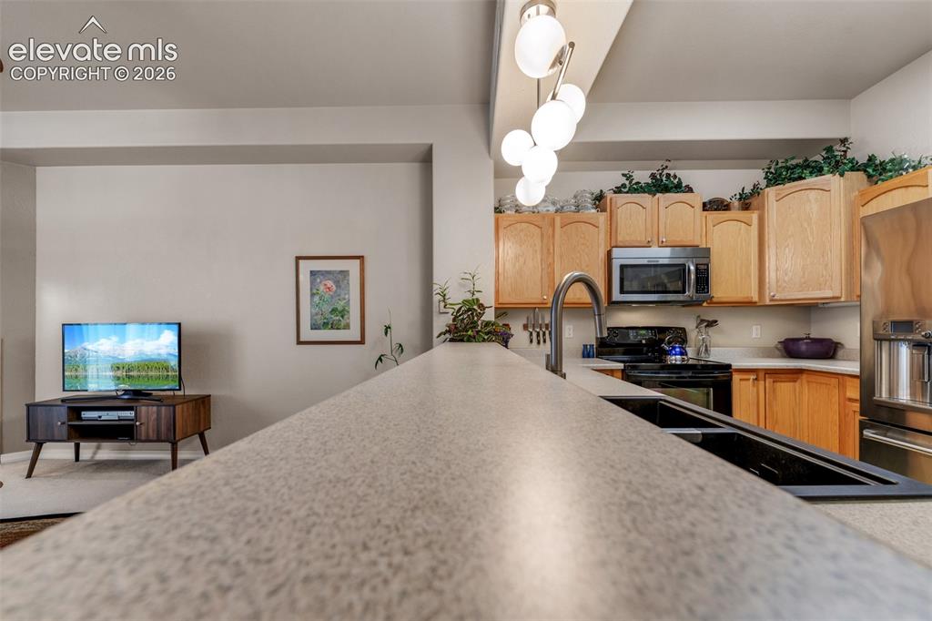 Image 7 of 32: Kitchen featuring light wood cabinetry, white countertops, stainless steel 