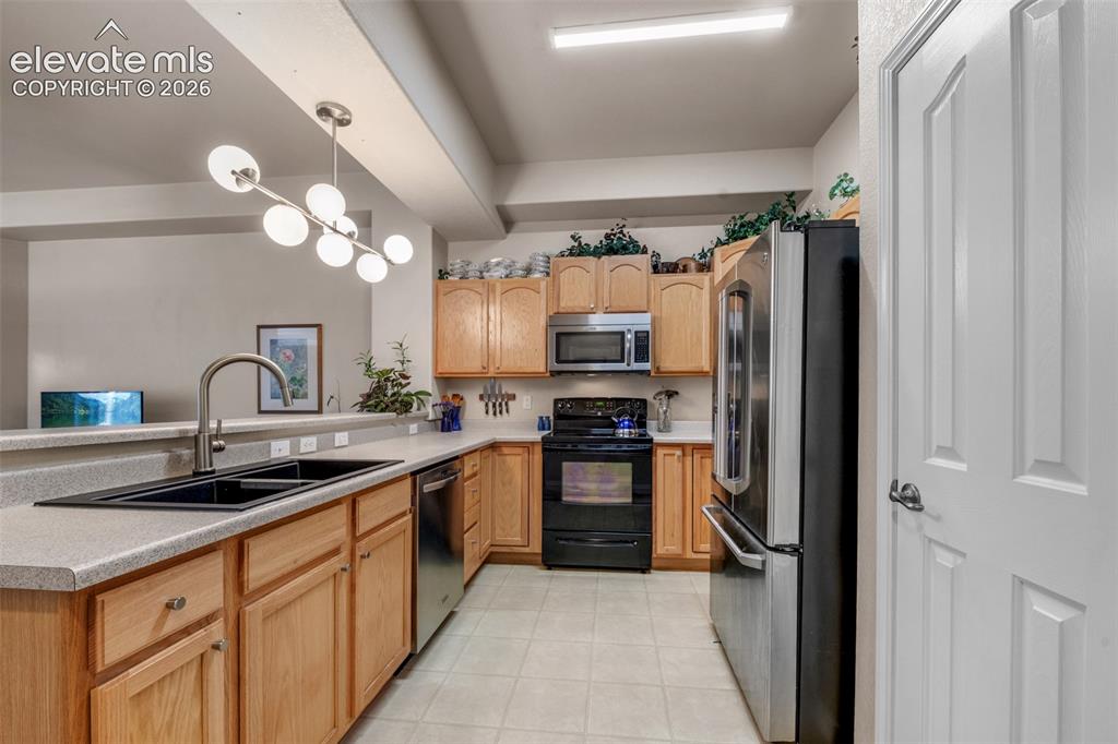 Image 8 of 32: Kitchen featuring wood-finish cabinetry, stainless steel appliances, a doub