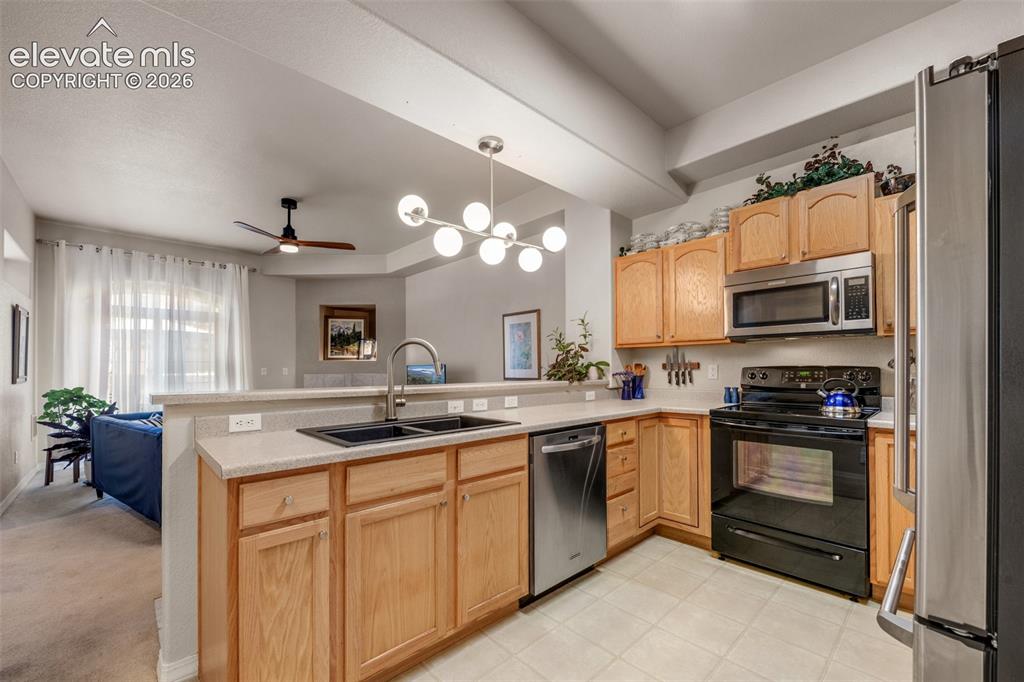 Image 9 of 32: Kitchen featuring wood cabinetry, white countertops, tile flooring, and sta