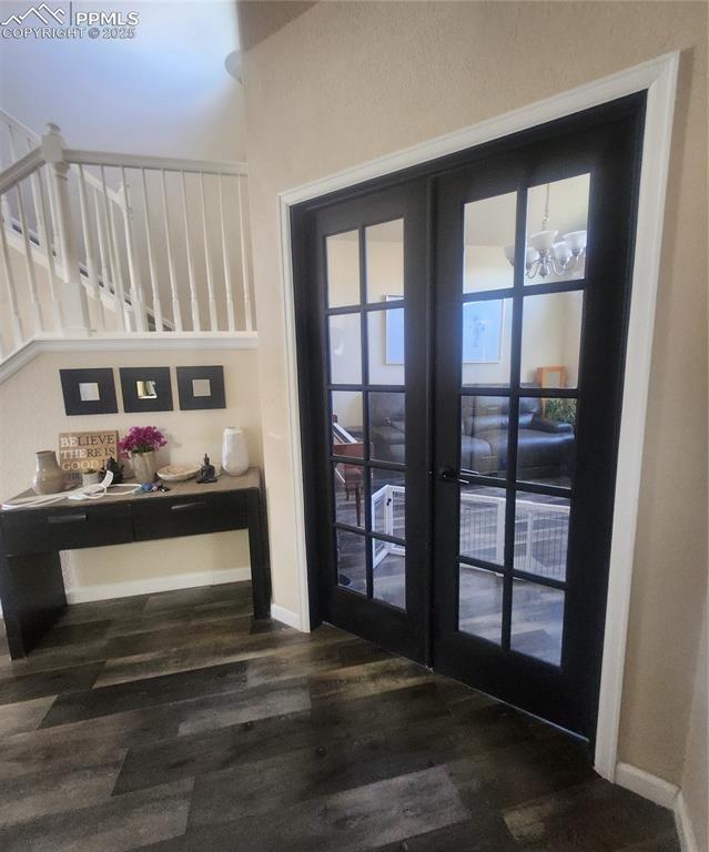 Image 10 of 45: Entryway featuring wood finished floors, stairway, and french doors