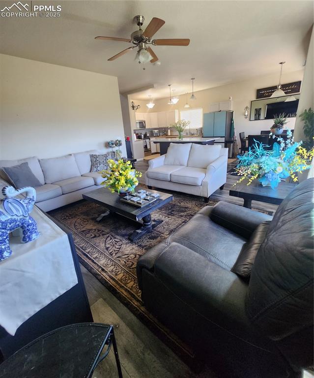Image 11 of 45: Living room featuring a ceiling fan and wood finished floors