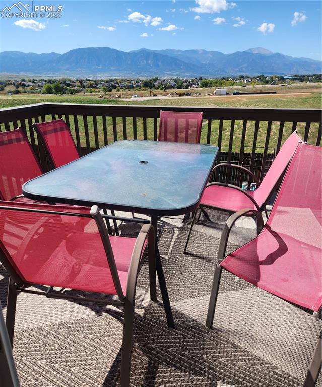 Image 16 of 45: Wooden terrace with outdoor dining space and a mountain view