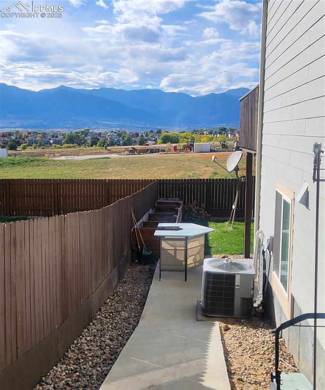 Image 18 of 45: Fenced backyard featuring a mountain view and a patio area
