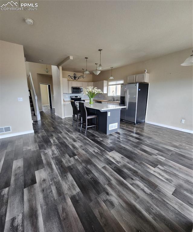 Image 42 of 45: Kitchen with appliances with stainless steel finishes, a kitchen island, pe