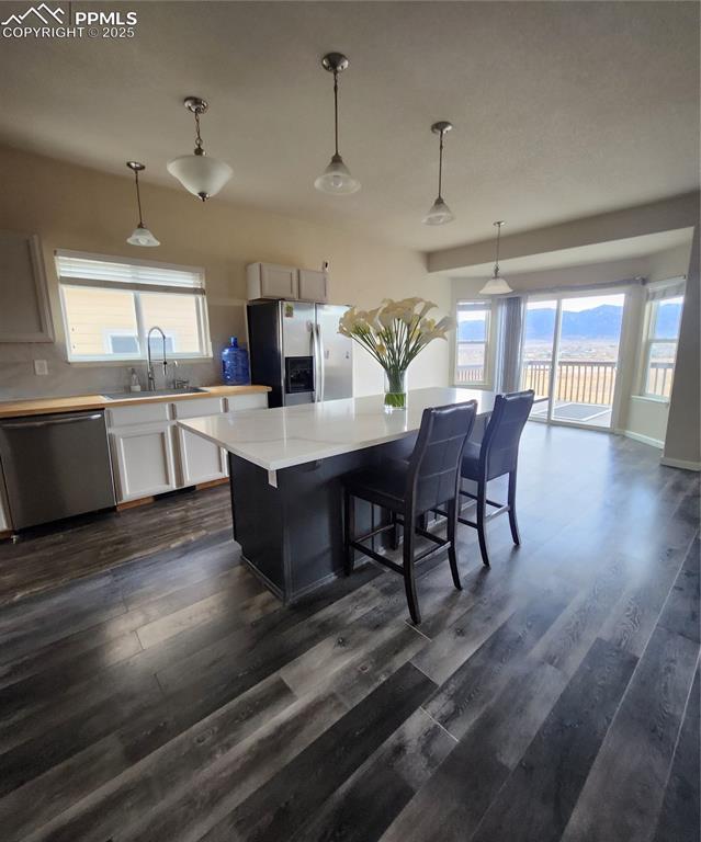 Image 43 of 45: Kitchen featuring decorative light fixtures, refrigerator, dishwashing mach