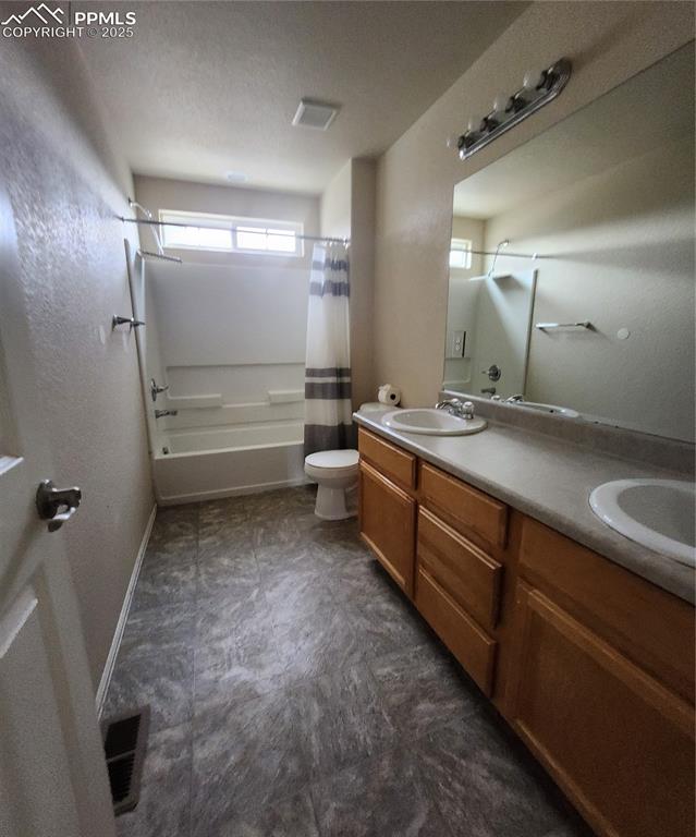 Image 45 of 45: Bathroom featuring double vanity, shower / tub combo, a textured ceiling, a