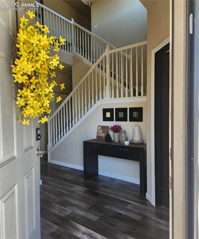 Image 9 of 45: Entrance foyer featuring stairway, dark wood-style floors, and a towering c