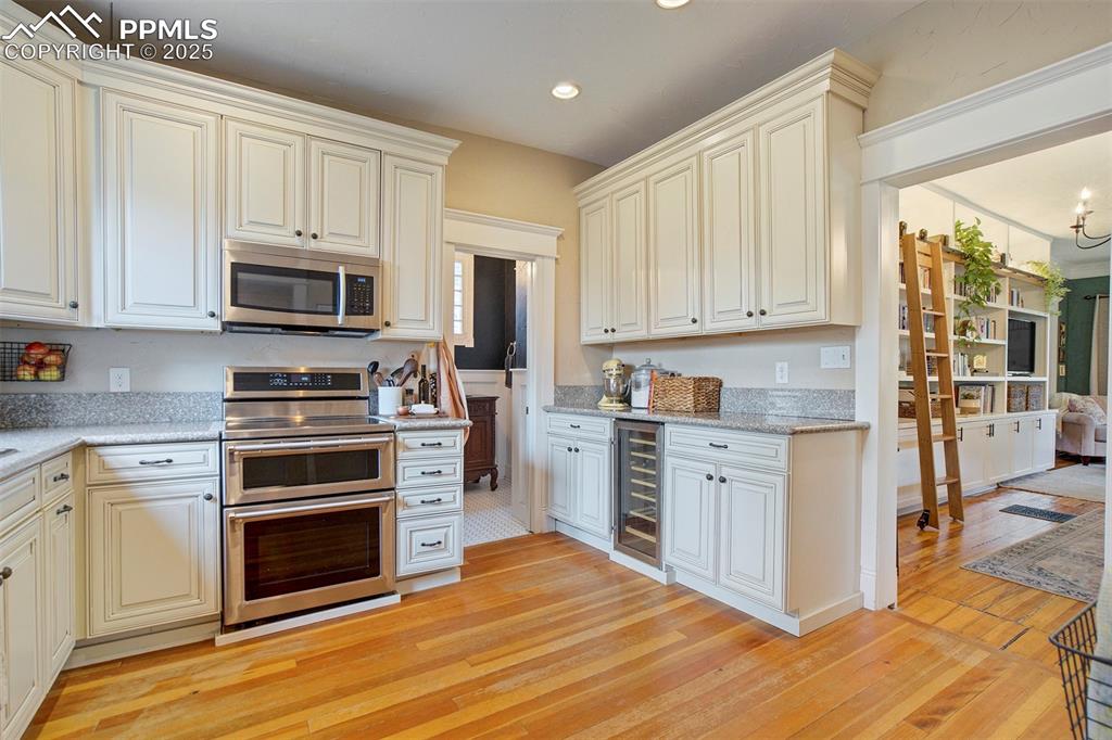 Image 13 of 37: Kitchen featuring appliances with stainless steel finishes, light stone cou