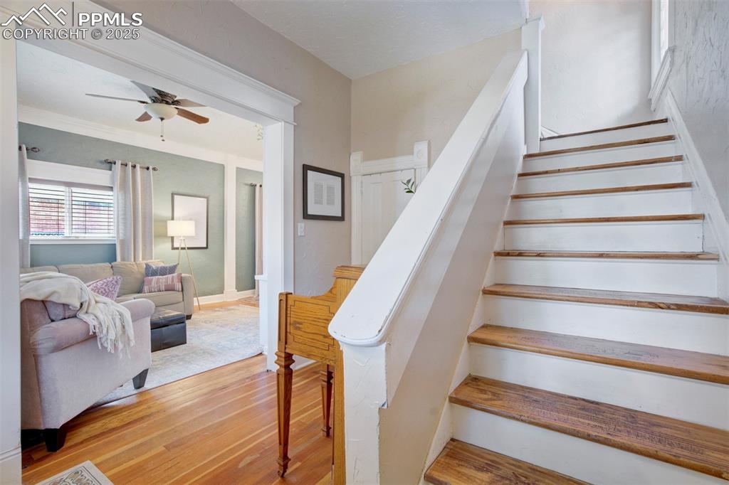 Image 20 of 37: Stairway featuring wood finished floors and ceiling fan