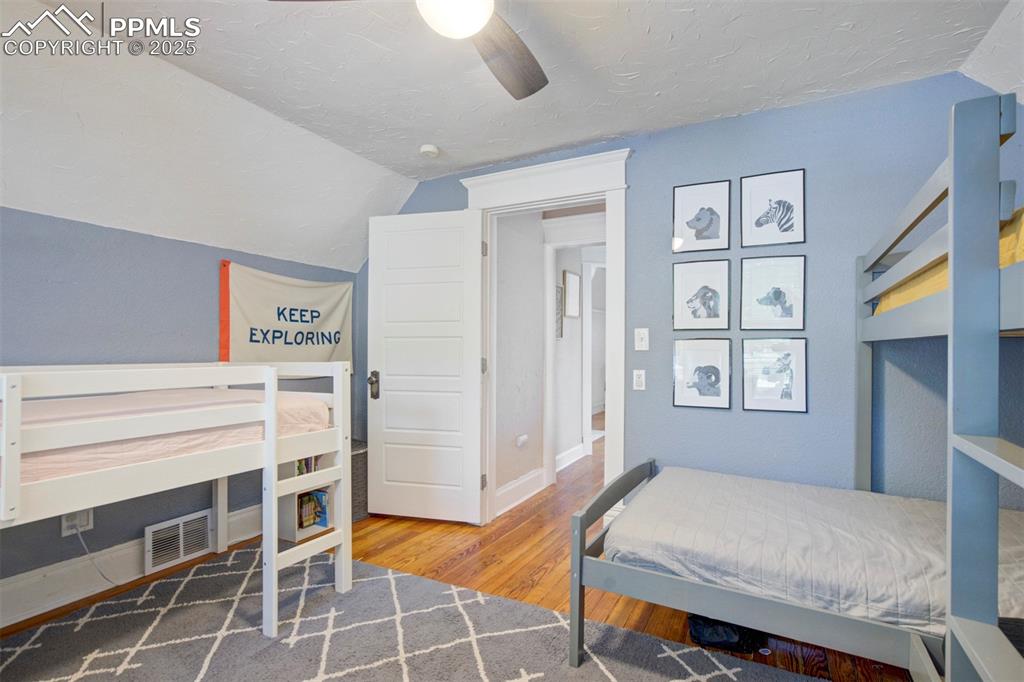Image 25 of 37: Bedroom featuring light wood-type flooring, lofted ceiling, a ceiling fan,