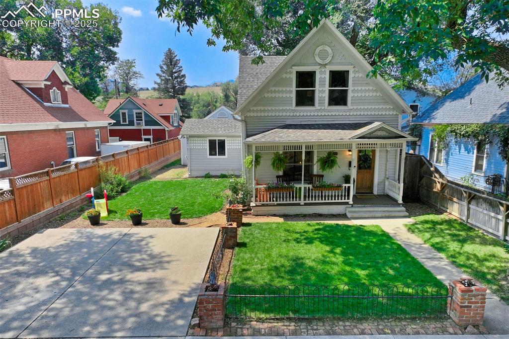 Image 37 of 37: Victorian-style house featuring a fenced backyard, a porch, and roof with s