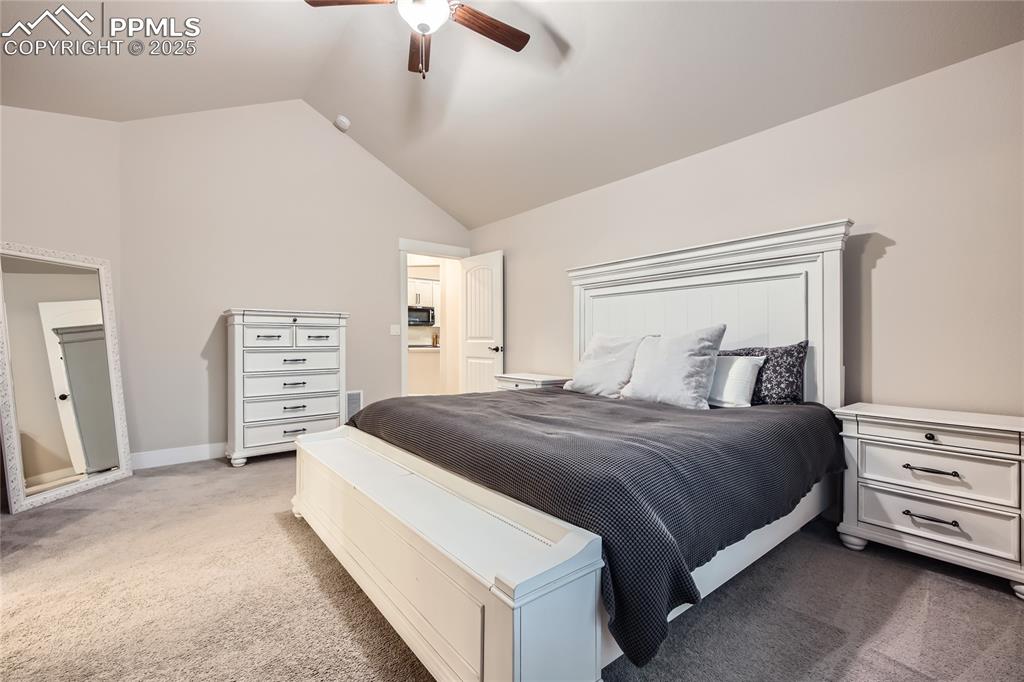 Image 13 of 37: Carpeted bedroom with lofted ceiling and a ceiling fan