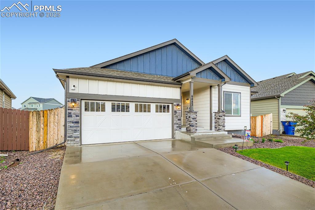 Image 2 of 37: View of front of home featuring board and batten siding, concrete driveway,
