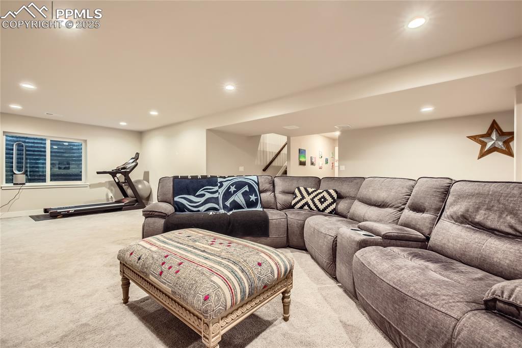 Image 20 of 37: Living area featuring light colored carpet, recessed lighting, and stairs