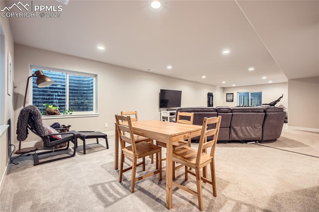 Image 21 of 37: Dining space with light carpet and recessed lighting