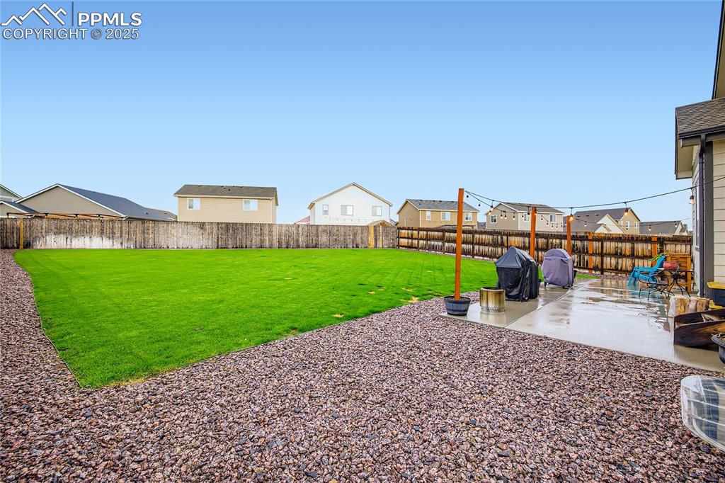 Image 26 of 37: Fenced backyard with a patio and a residential view