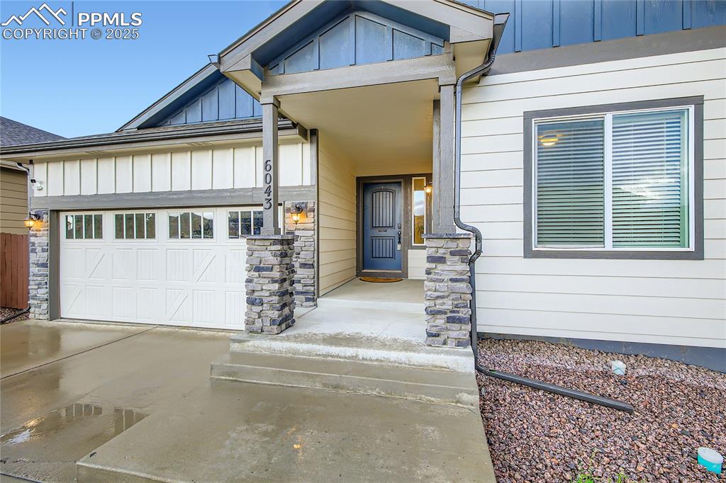 Image 3 of 37: View of front of house featuring board and batten siding, a garage, and dri