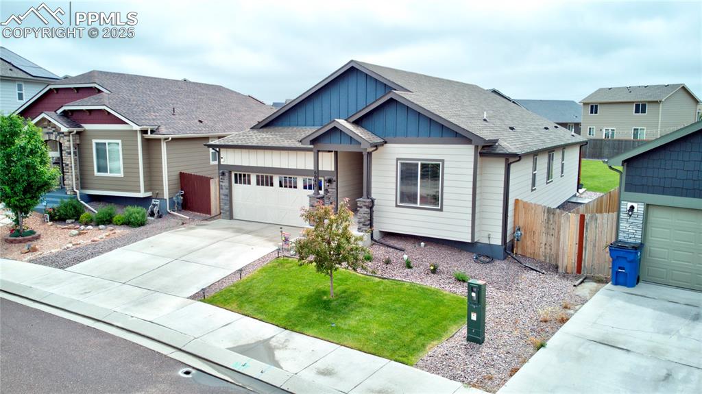 Image 33 of 37: Craftsman-style house featuring board and batten siding, driveway, a garage