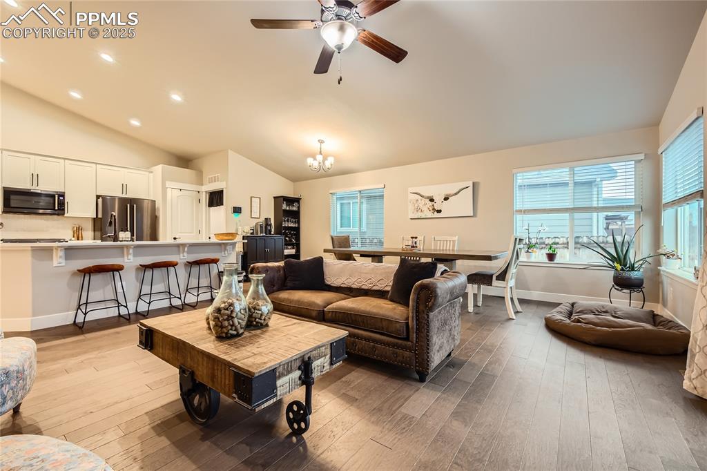 Image 5 of 37: Living area with hardwood / wood-style floors, a chandelier, recessed light